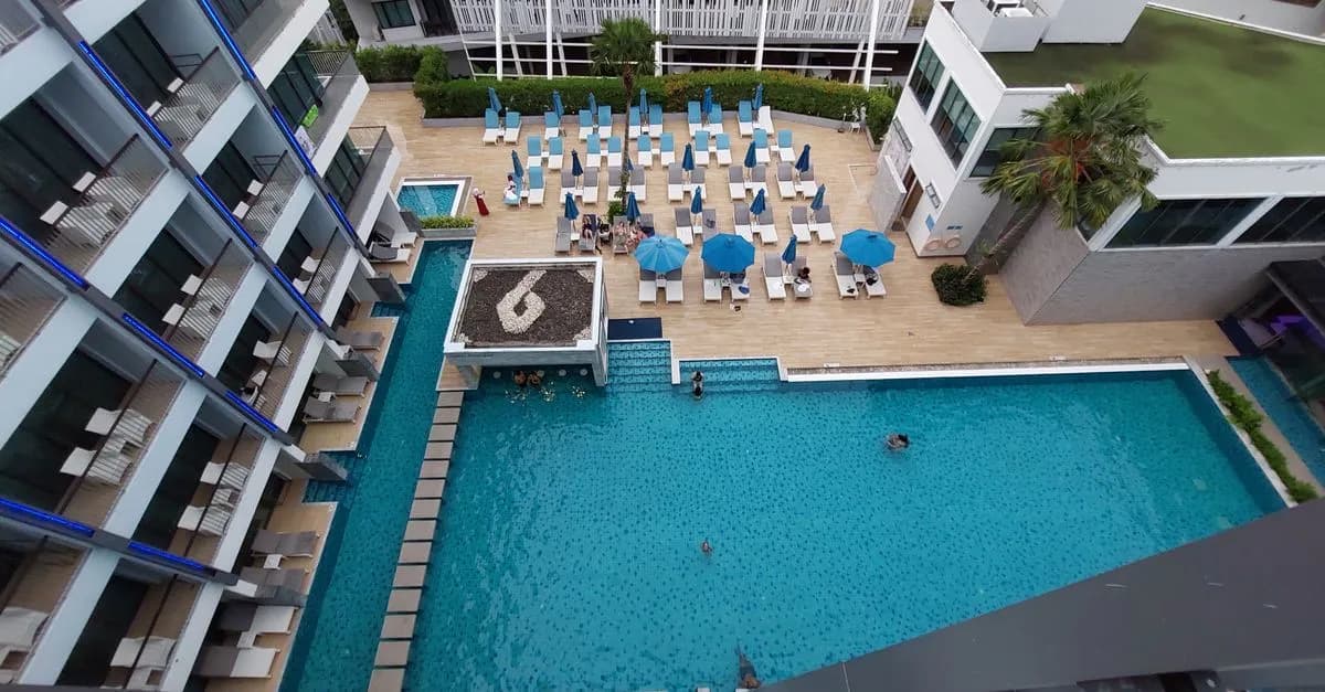 Aerial view of modern resort with swimming pool and sun loungers in Krabi, Thailand.