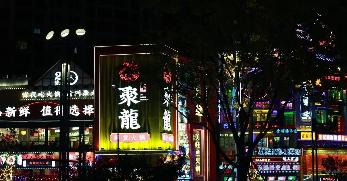 Colorful neon signs illuminate a bustling city street at night, showcasing vibrant Asian culture.
