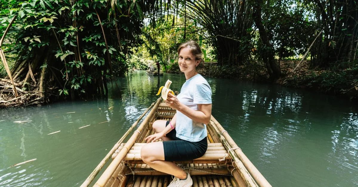 Woman relaxing on a bamboo raft in Krabi, Thailand, surrounded by lush greenery.