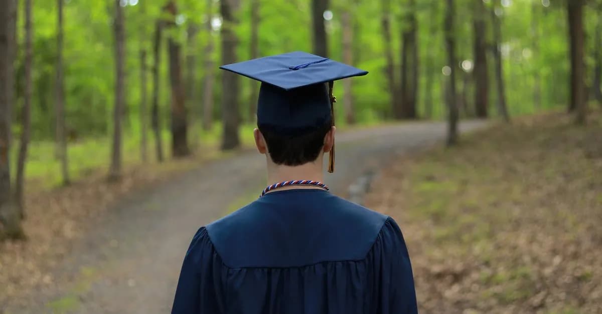 Graduate walking through a serene forest path, symbolizing new beginnings.