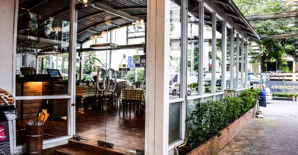 Modern restaurant with large glass windows and entrance, featuring contemporary interior design.