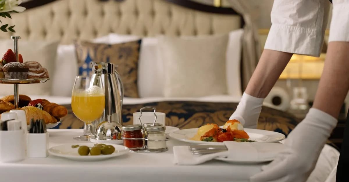 Elegant room service breakfast with orange juice and pastries in a hotel room.