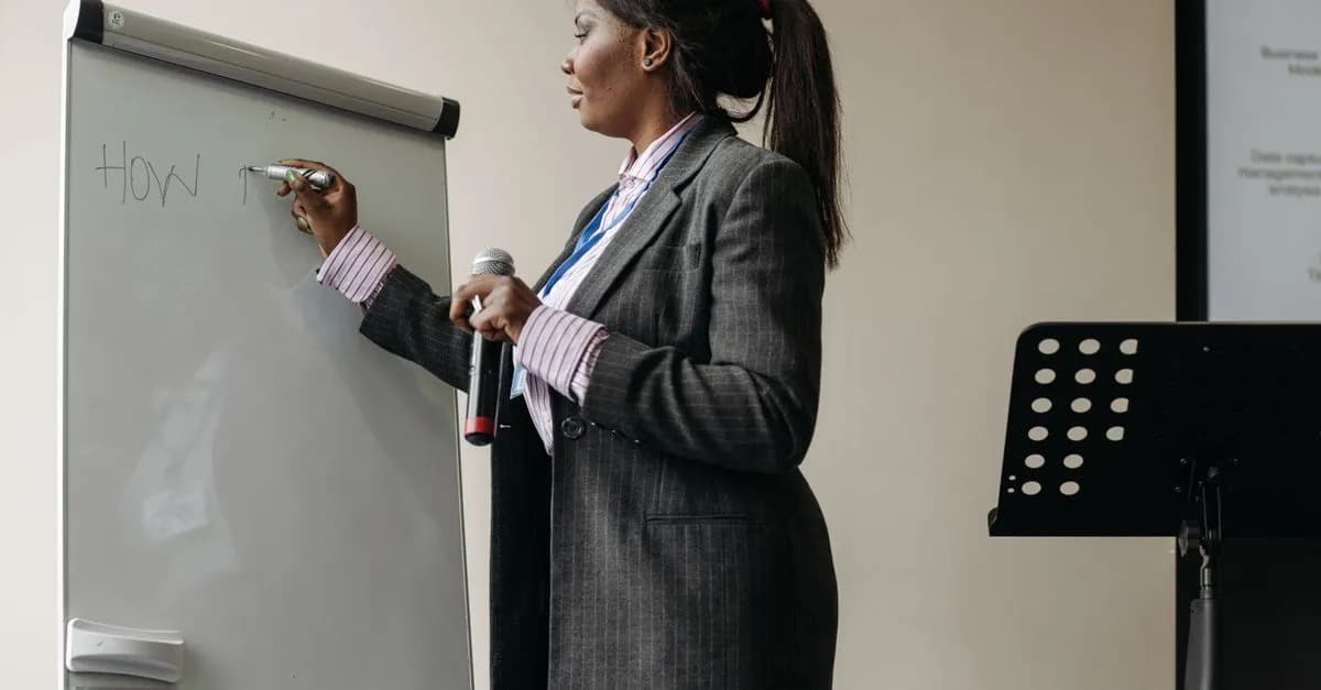 Confident businesswoman presenting ideas on a whiteboard during a seminar.